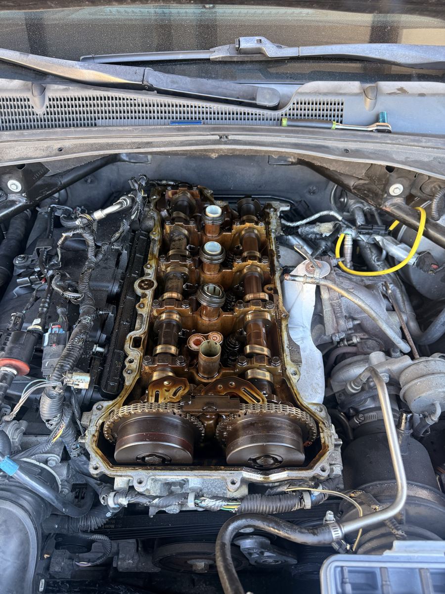 Engine with valve cover removed, showing camshafts and timing chain