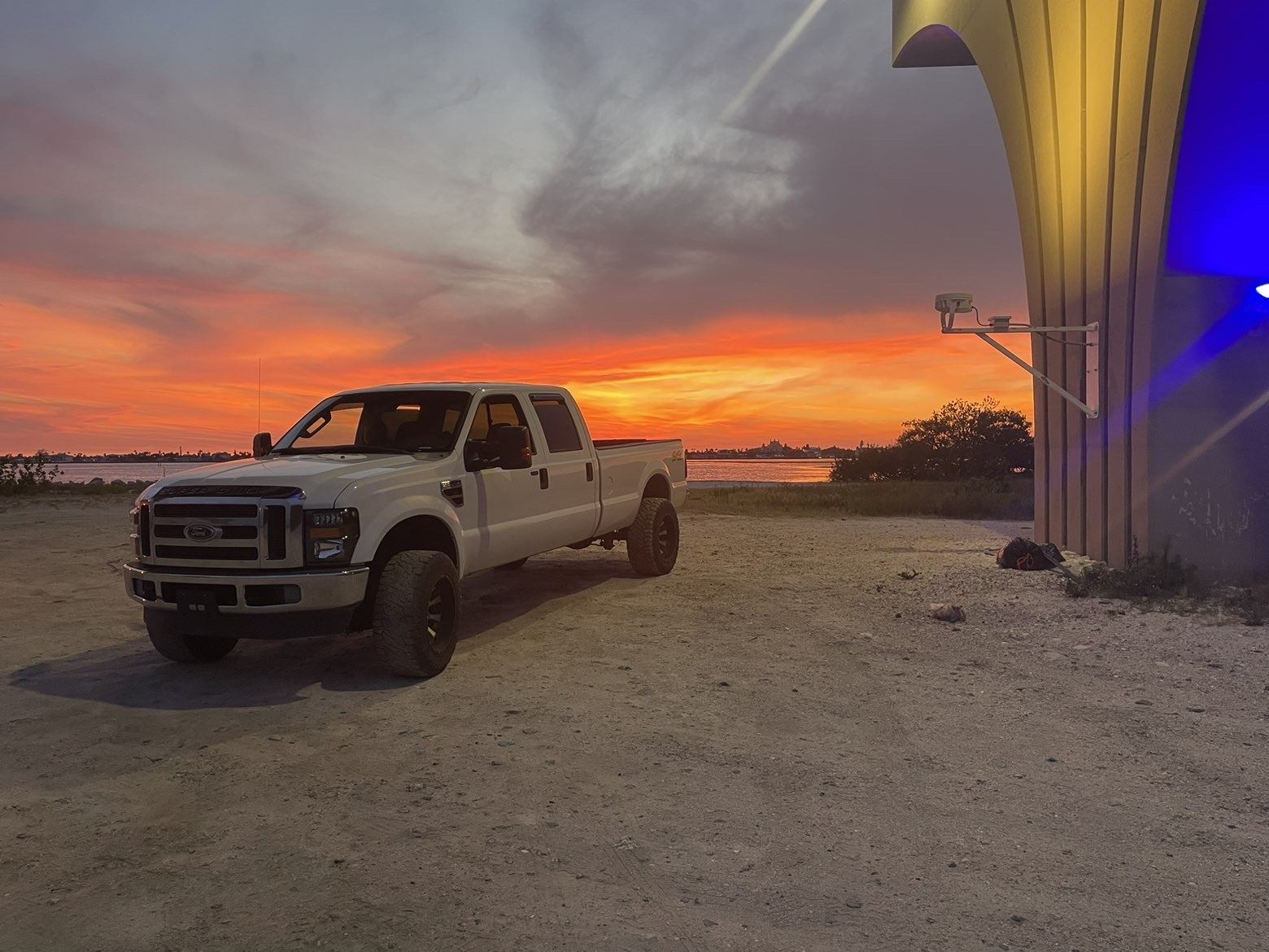 Raymond's white Ford Super Duty service truck at sunset on the water in Pinellas County